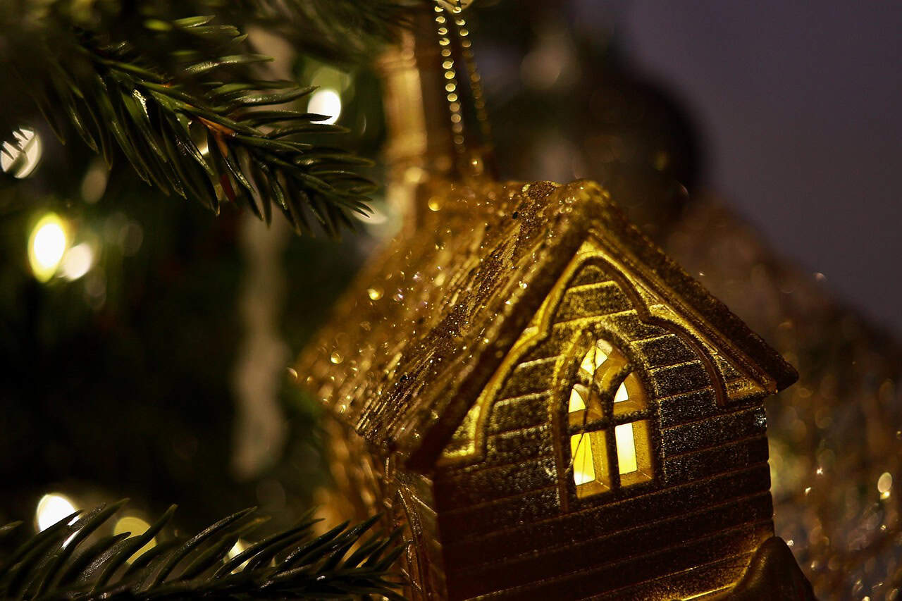 House dangling off Christmas tree.
